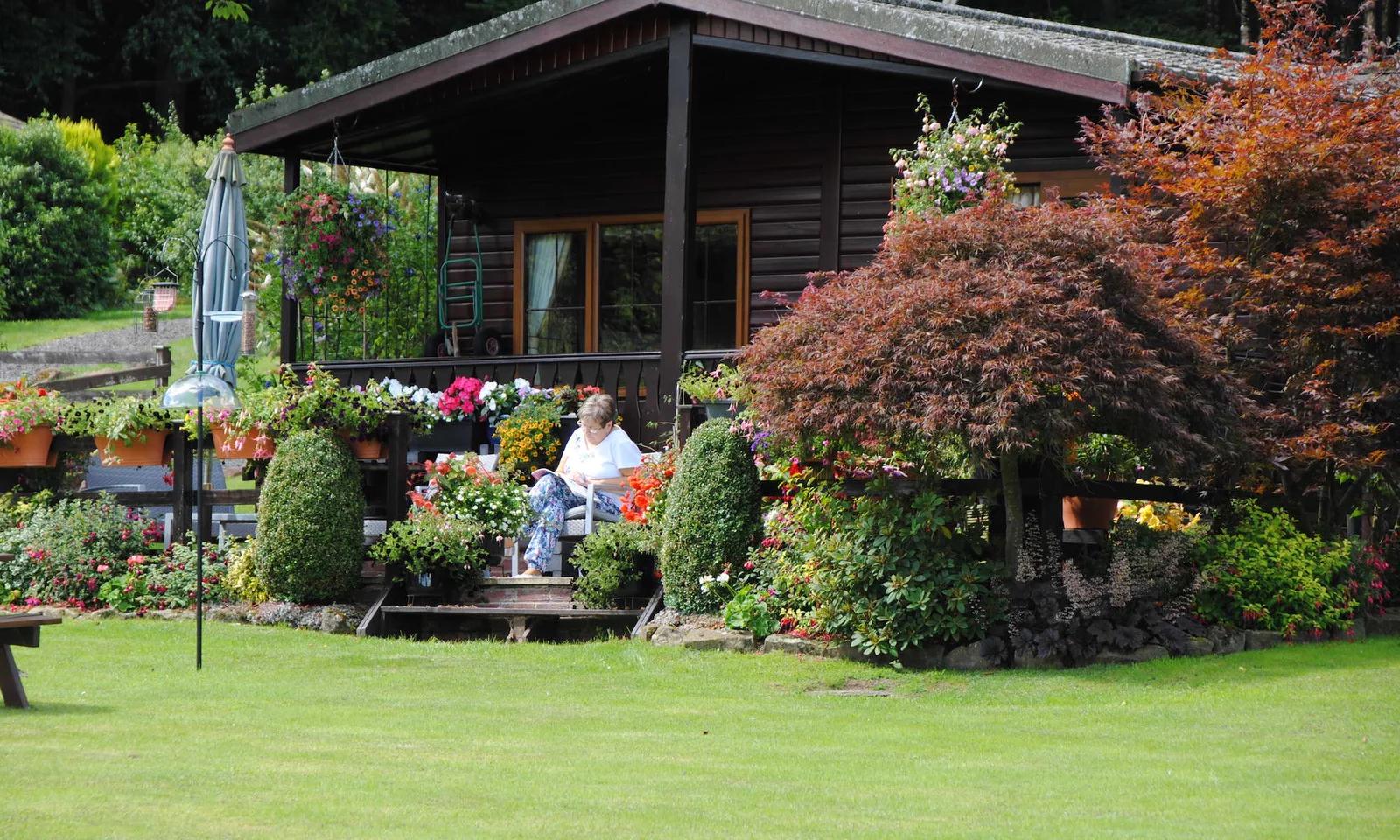 Lady reading outside a lodge at Coppice gate